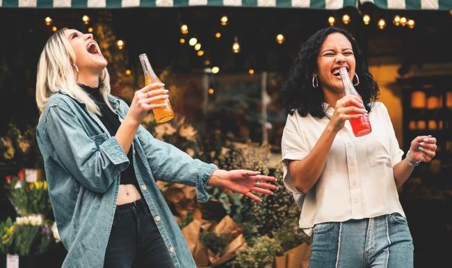 The essence of exceptional living a couple of women singing and holding drinks